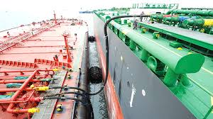 Bunker barge delivering marine fuel to vessel at port